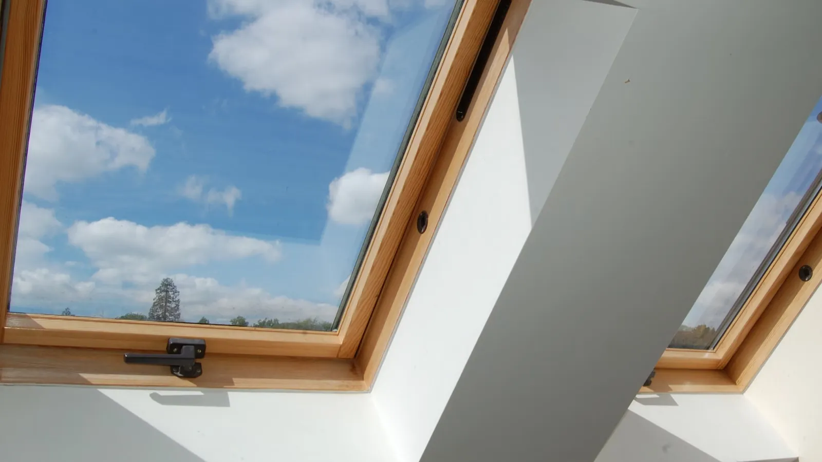 Finished roof window installation with blue-sky view.
