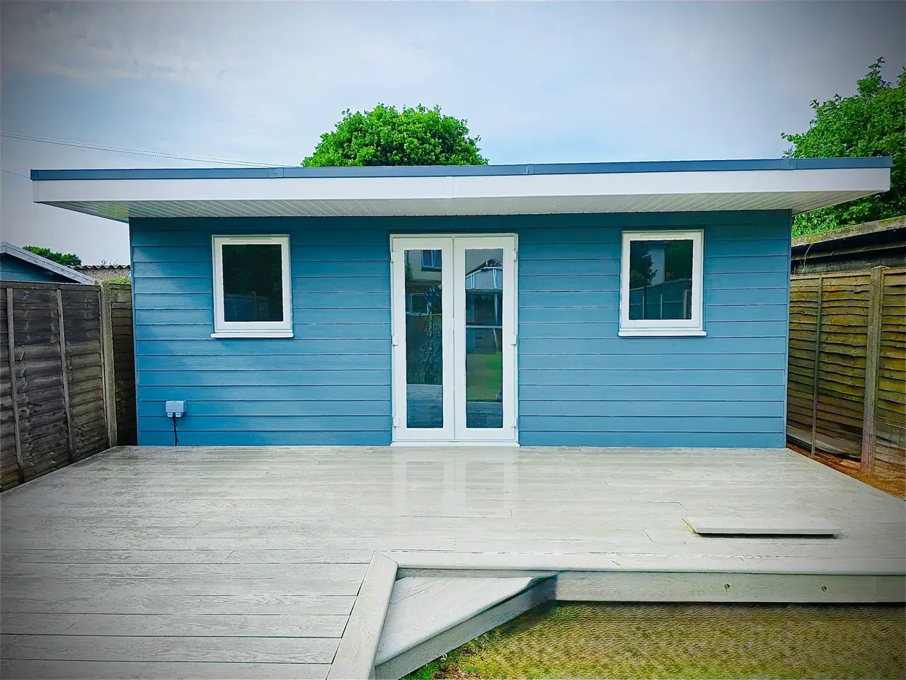 Blue timber garden room with deck and French doors